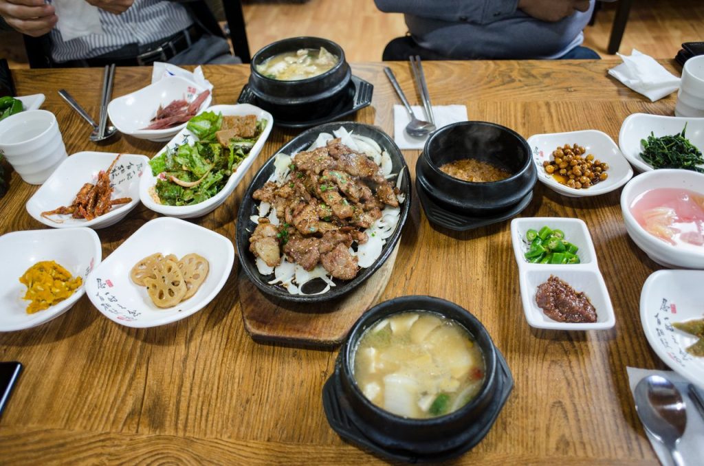 Welcome to Priory Park Cafe An overhead view of various Korean dishes served on a wooden table, showcasing traditional cuisine.